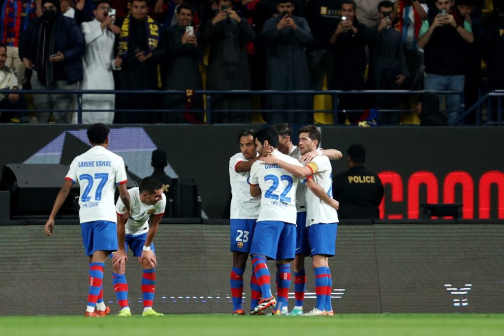 RIYADH, SAUDI ARABIA - JANUARY 11: Robert Lewandowski of FC Barcelona (hidden) celebrates scoring his team's first goal with teammates during the Super Copa de Espana Semi-Final match between FC Barcelona and CA Osasuna at Al-Awwal Park on January 11, 2024 in Riyadh, Saudi Arabia.