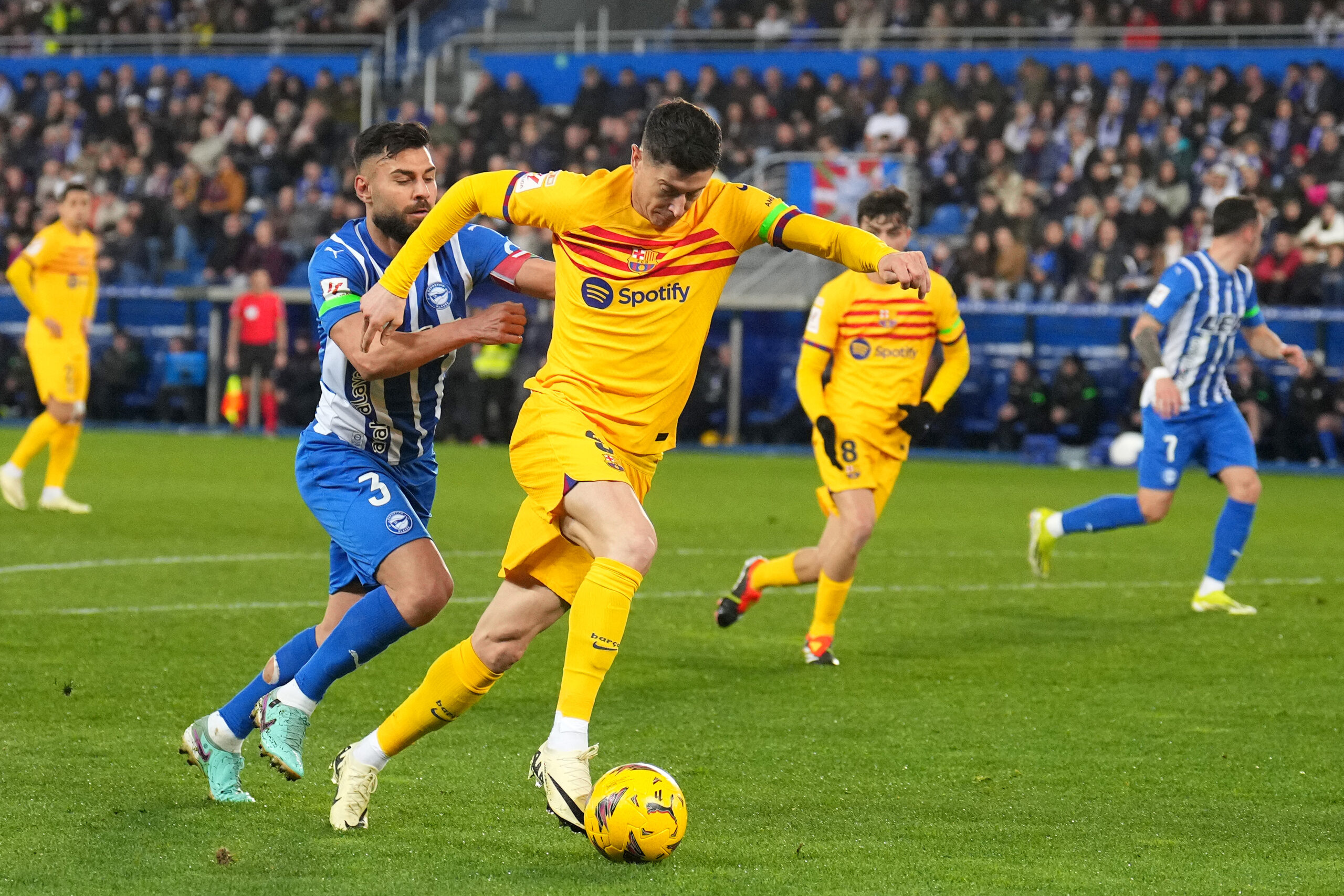 VITORIA-GASTEIZ, SPAIN - FEBRUARY 03: Robert Lewandowski of FC Barcelona runs with the ball under pressure from Ruben Duarte of Deportivo Alaves during the LaLiga EA Sports match between Deportivo Alaves and FC Barcelona at Estadio de Mendizorroza on February 03, 2024 in Vitoria-Gasteiz, Spain.