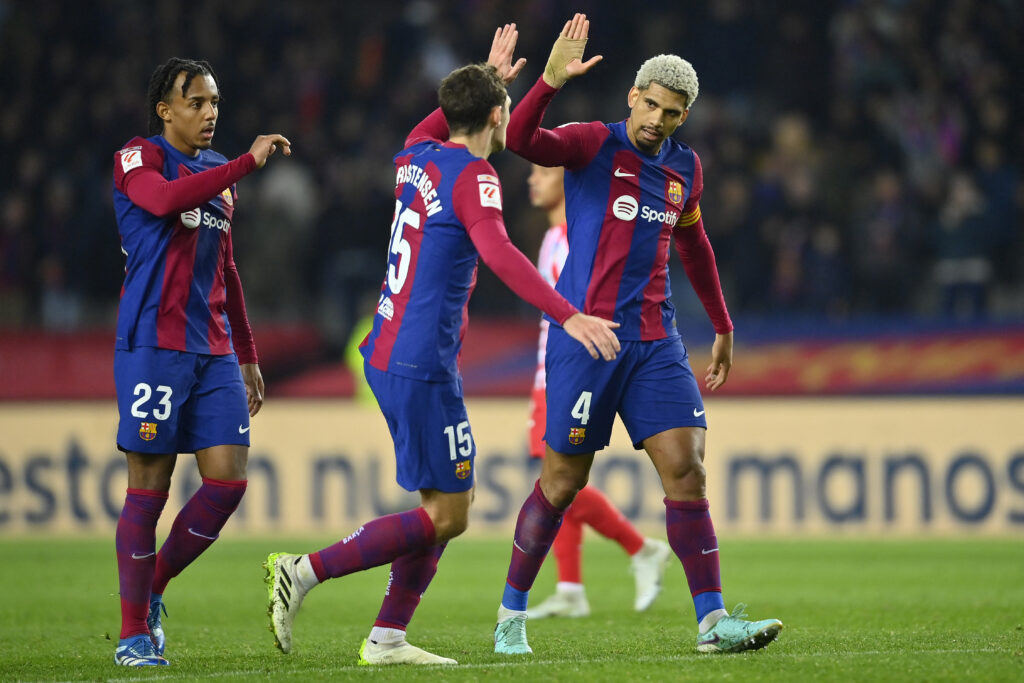 (From L) Barcelona's French defender #23 Jules Kounde, Barcelona's Danish defender #15 Andreas Christensen and Barcelona's Uruguayan defender #04 Ronald Araujo celebrate their win at the end of the Spanish league football match between FC Barcelona and Club Atletico de Madrid at the Estadi Olimpic Lluis Companys in Barcelona on December 3, 2023.