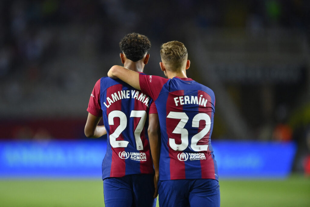 Barcelona's Spanish forward #27 Lamine Yamal and Barcelona's Spanish midfielder #32 Fermin Lopez celebrate Sevilla's Spanish defender #04 Sergio Ramos' owngoal during the Spanish Liga football match between FC Barcelona and Sevilla FC at the Estadi Olimpic Lluis Companys in Barcelona on September 29, 2023.