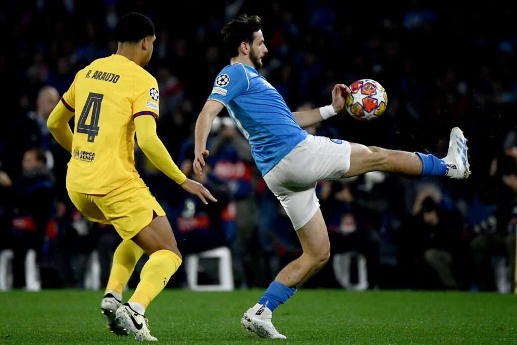 Napoli's Georgian forward #77 Khvicha Kvaratskhelia (R) controls the ball in front of Barcelona's Uruguayan defender #04 Ronald Araujo (L) during the UEFA Champions League round of 16 first Leg football match between Napoli and Barcelona at the Diego-Armando-Maradona stadium in Naples on February 21, 2024.