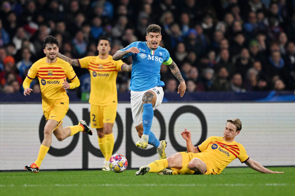 NAPLES, ITALY - FEBRUARY 21: Giovanni Di Lorenzo of SSC Napoli is fouled by Frenkie de Jong of FC Barcelona leading to a yellow card being shown during the UEFA Champions League 2023/24 round of 16 first leg match between SSC Napoli and FC Barcelona at Stadio Diego Armando Maradona on February 21, 2024 in Naples, Italy.