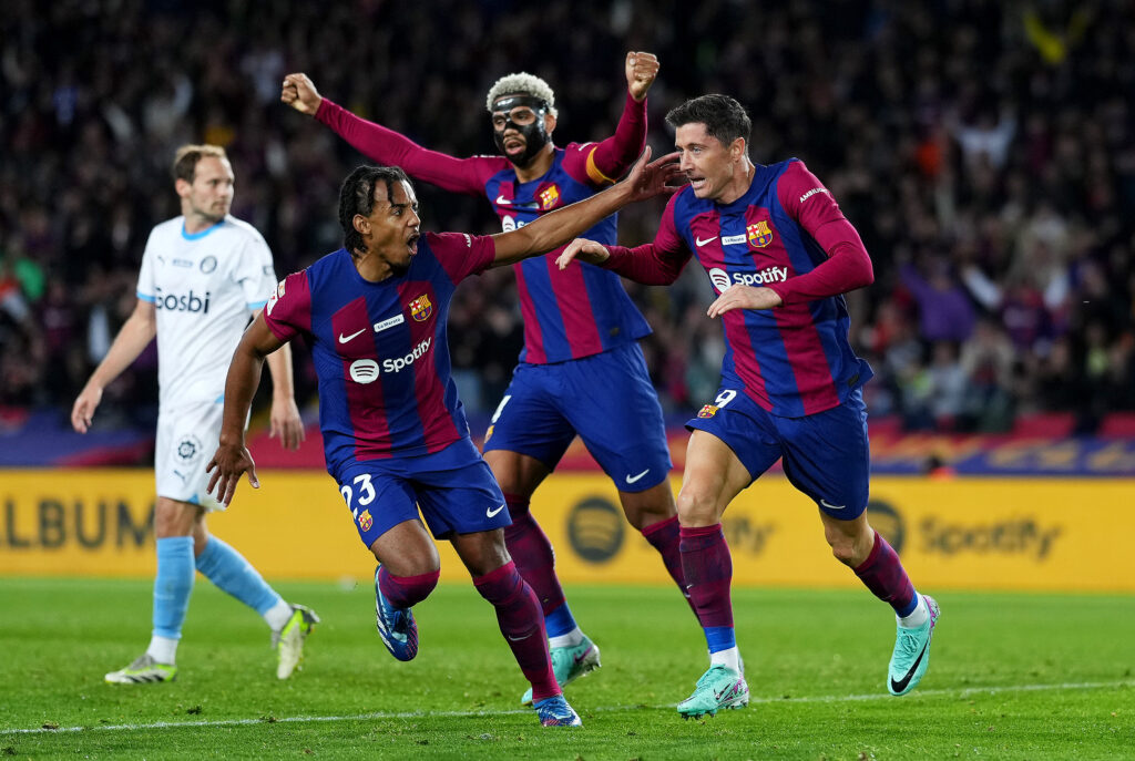 BARCELONA, SPAIN - DECEMBER 10: Robert Lewandowski of FC Barcelona celebrates with Jules Kounde and Ronald Araujo of FC Barcelona after scoring their team's first goal during the LaLiga EA Sports match between FC Barcelona and Girona FC at Estadi Olimpic Lluis Companys on December 10, 2023 in Barcelona, Spain.