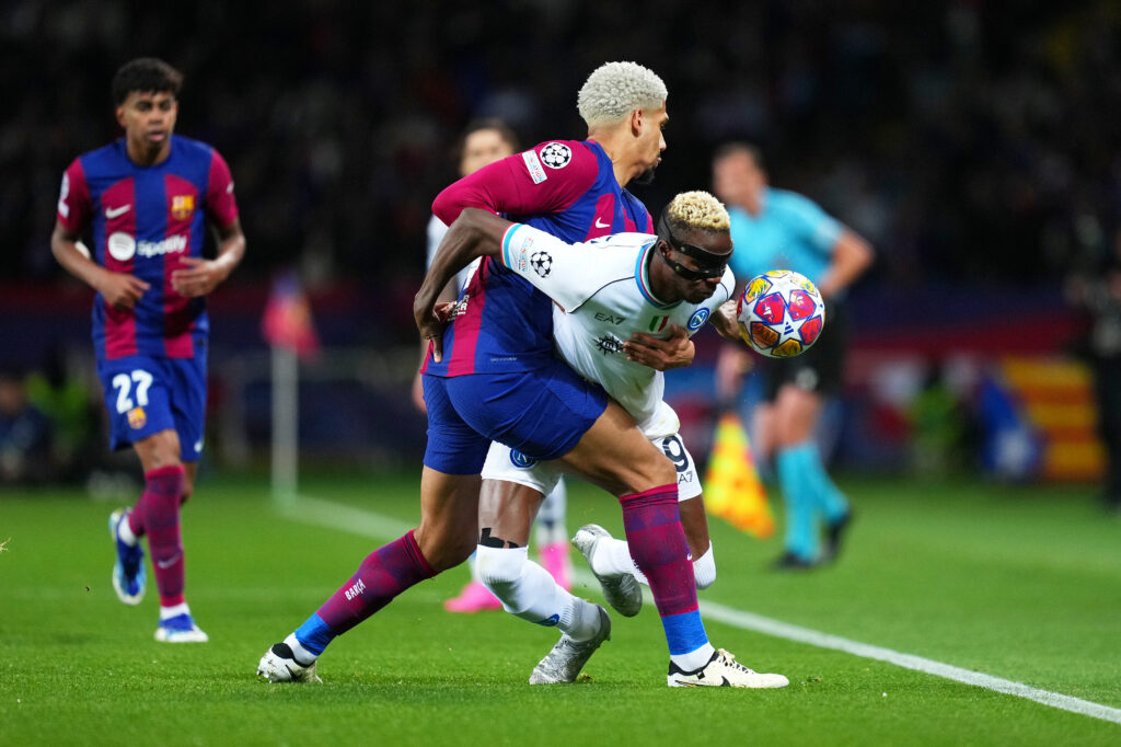 BARCELONA, SPAIN - MARCH 12: Victor Osimhen of SSC Napoli is challenged by Ronald Araujo of FC Barcelona during the UEFA Champions League 2023/24 round of 16 second leg match between FC Barcelona and SSC Napoli at Estadi Olimpic Lluis Companys on March 12, 2024 in Barcelona, Spain.