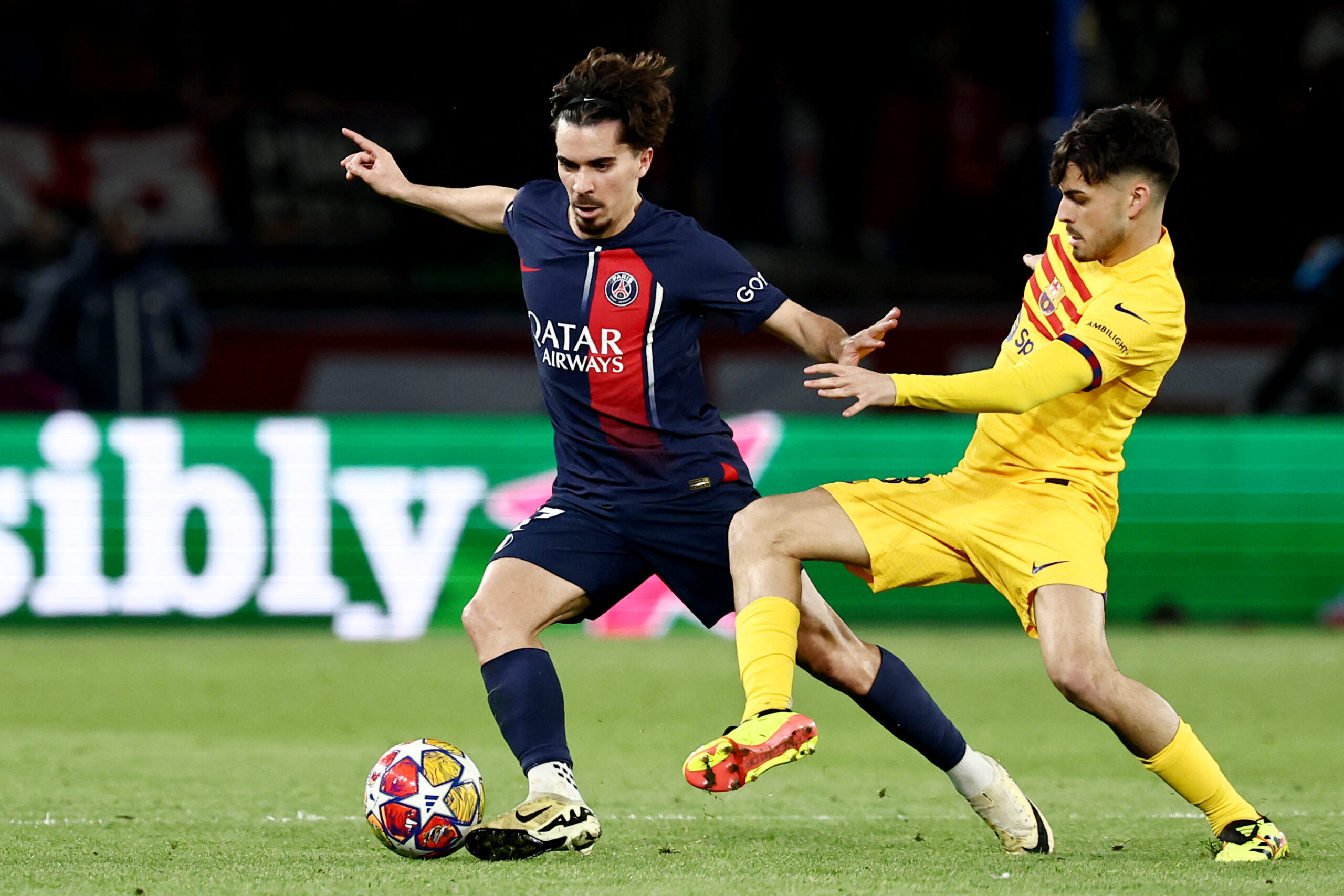 Paris Saint-Germain's Portuguese midfielder #17 Vitinha (L) and Barcelona's Spanish midfielder #08 Pedri (R) fight for the ball during the UEFA Champions League quarter final first leg football match between Paris Saint-Germain (PSG) and FC Barcelona at the Parc des Princes stadium in Paris on April 10, 2024.