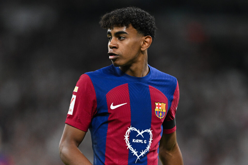 MADRID, SPAIN - APRIL 21: Lamine Yamal of FC Barcelona looks on whilst wearing a Karol G limited edition match shirt during the LaLiga EA Sports match between Real Madrid CF and FC Barcelona at Estadio Santiago Bernabeu on April 21, 2024 in Madrid, Spain.