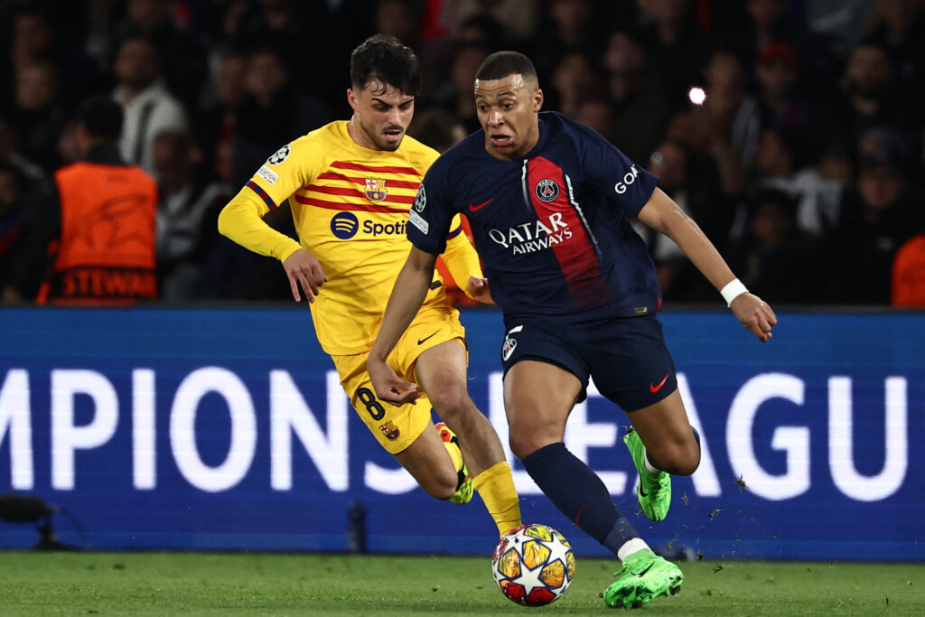 TOPSHOT - Paris Saint-Germain's French forward #07 Kylian Mbappe (R) runs with the ball ahead of Barcelona's Spanish midfielder #08 Pedri (L) during the UEFA Champions League quarter final first leg football match between Paris Saint-Germain (PSG) and FC Barcelona at the Parc des Princes stadium in Paris on April 10, 2024.