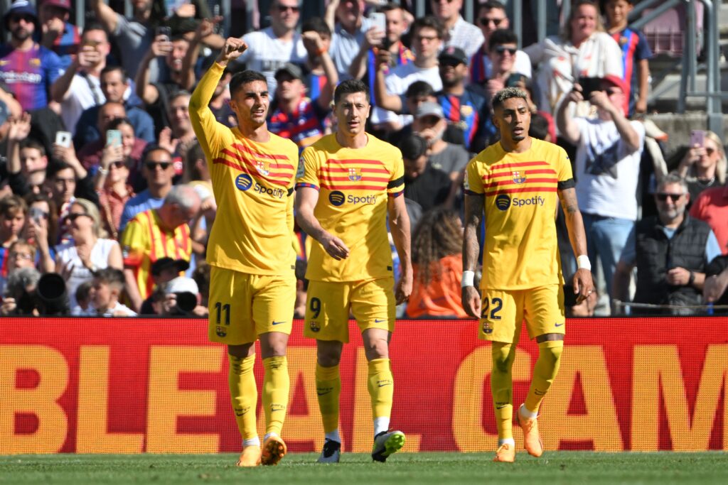 Barcelona's Spanish forward Ferran Torres (L) celebrates scoring his team's first goal with Barcelona's Polish forward Robert Lewandowski and Barcelona's Brazilian forward Raphinha (R) during the Spanish league football match between FC Barcelona and Club Atletico de Madrid at the Camp Nou stadium in Barcelona on April 23, 2023.