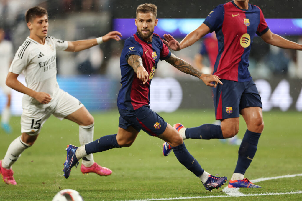 Barcelona's Spanish defender #05 Inigo Martinez (C) gestures under the pressure of Real Madrid's Turkish midfielder #15 Arda Guler (L) during the pre-season club friendly football match between Real Madrid and Barcelona at MetLife Stadium in East Rutherford, New Jersey, August 3, 2024.