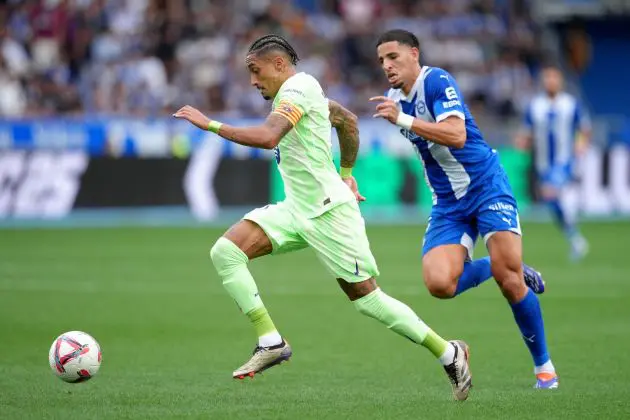 VITORIA-GASTEIZ, SPAIN - OCTOBER 06: Raphinha of FC Barcelona runs ahead of Abdelkabir Abqar of Alaves during the LaLiga match between Deportivo Alaves and FC Barcelona at Estadio de Mendizorroza on October 06, 2024 in Vitoria-Gasteiz, Spain.