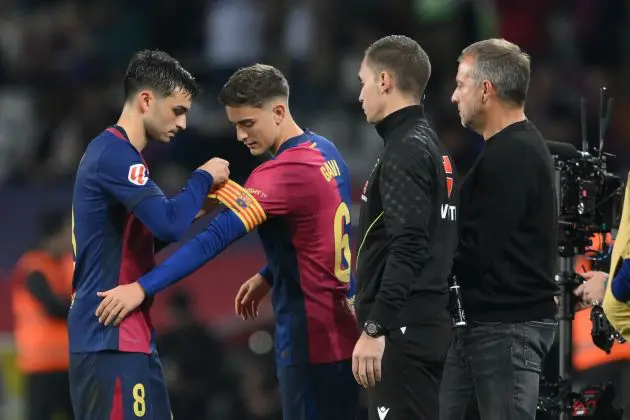 BARCELONA, SPAIN - OCTOBER 20: Pedri of FC Barcelona attaches the captain's armband onto the arm of teammate Gavi whilst being substituted during the La Liga EA Sports match between FC Barcelona and Sevilla FC at Estadi Olimpic Lluis Companys on October 20, 2024 in Barcelona, Spain.