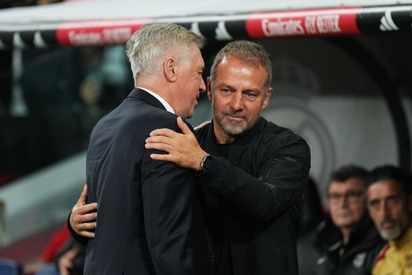 MADRID, SPAIN - OCTOBER 26: Hansi Flick, Head Coach of FC Barcelona, interacts with Carlo Ancelotti, Head Coach of Real Madrid, prior to the LaLiga match between Real Madrid CF and FC Barcelona at Estadio Santiago Bernabeu on October 26, 2024 in Madrid, Spain.