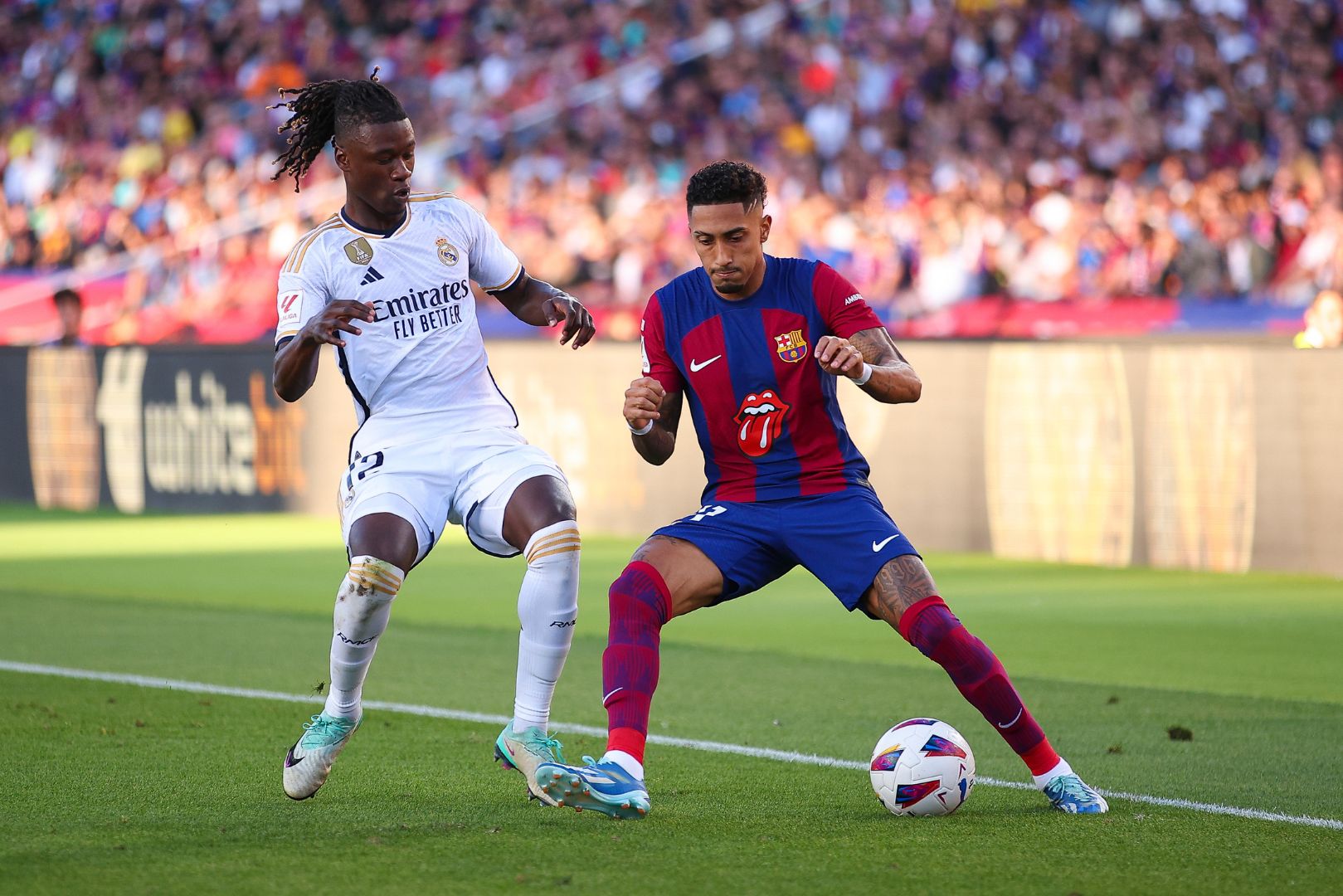 BARCELONA, SPAIN - OCTOBER 28: Raphinha of FC Barcelona is tackled by Eduardo Camavinga of Real Madrid during the LaLiga EA Sports match between FC Barcelona and Real Madrid CF at Estadi Olimpic Lluis Companys on October 28, 2023 in Barcelona, Spain.