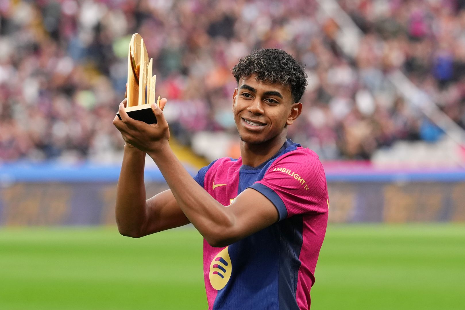 BARCELONA, SPAIN - NOVEMBER 03: Lamine Yamal of FC Barcelona acknowledges the fans as he displays his 2024 Kopa Trophy prior to the La Liga EA Sports match between FC Barcelona and RCD Espanyol at Estadi Olimpic Lluis Companys on November 03, 2024 in Barcelona, Spain.