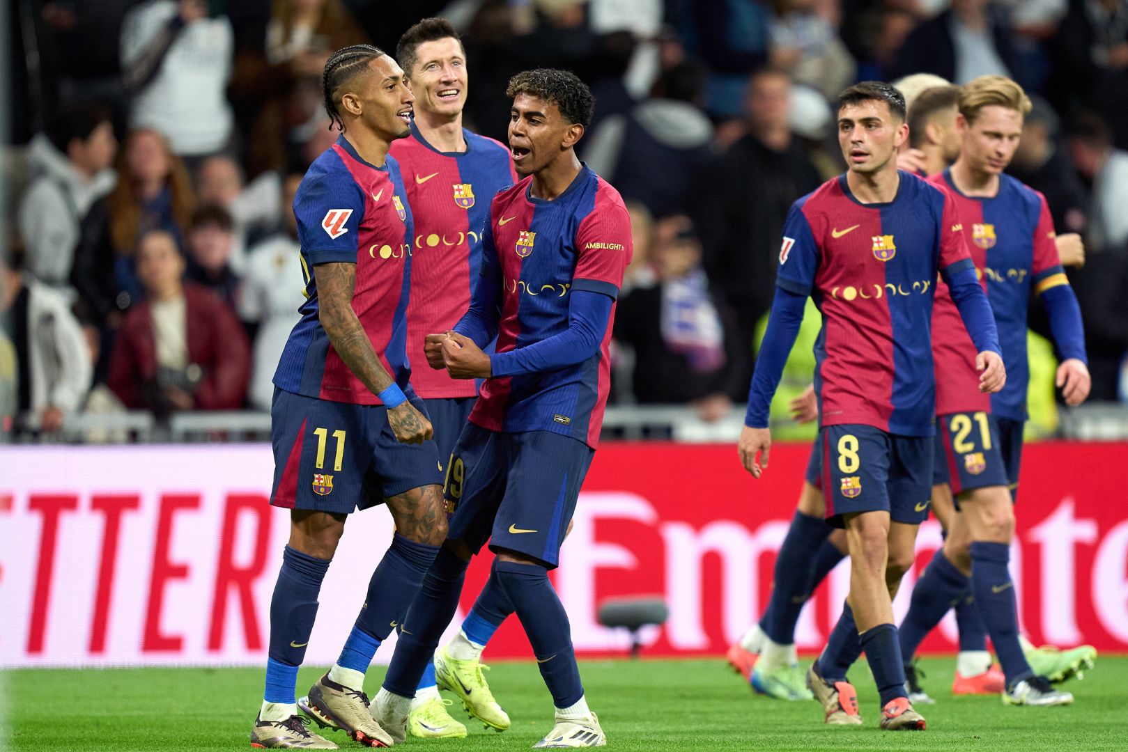 MADRID, SPAIN - OCTOBER 26: Raphinha of FC Barcelona celebrates scoring his team's fourth goal with teammates Robert Lewandowski and Lamine Yamal during the LaLiga match between Real Madrid CF and FC Barcelona at Estadio Santiago Bernabeu on October 26, 2024 in Madrid, Spain.