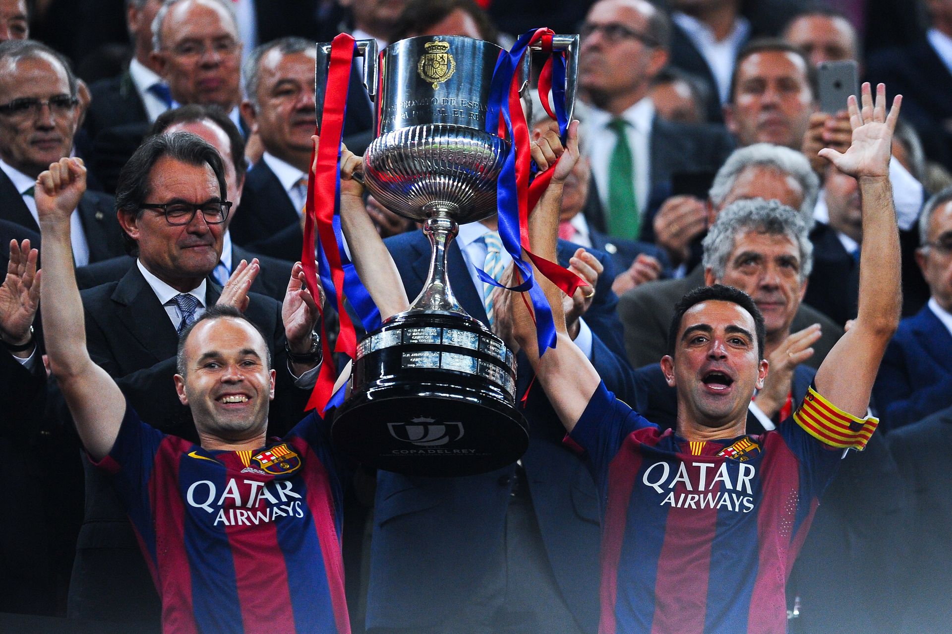 BARCELONA, SPAIN - MAY 30: FC Barcelona players Andres Iniesta (L) and Xavi Hernandez of FC Barcelona celebrate with the trophy after winning the Copa del Rey Final match between FC Barcelona and Athletic Club at Camp Nou on May 30, 2015 in Barcelona, Spain.