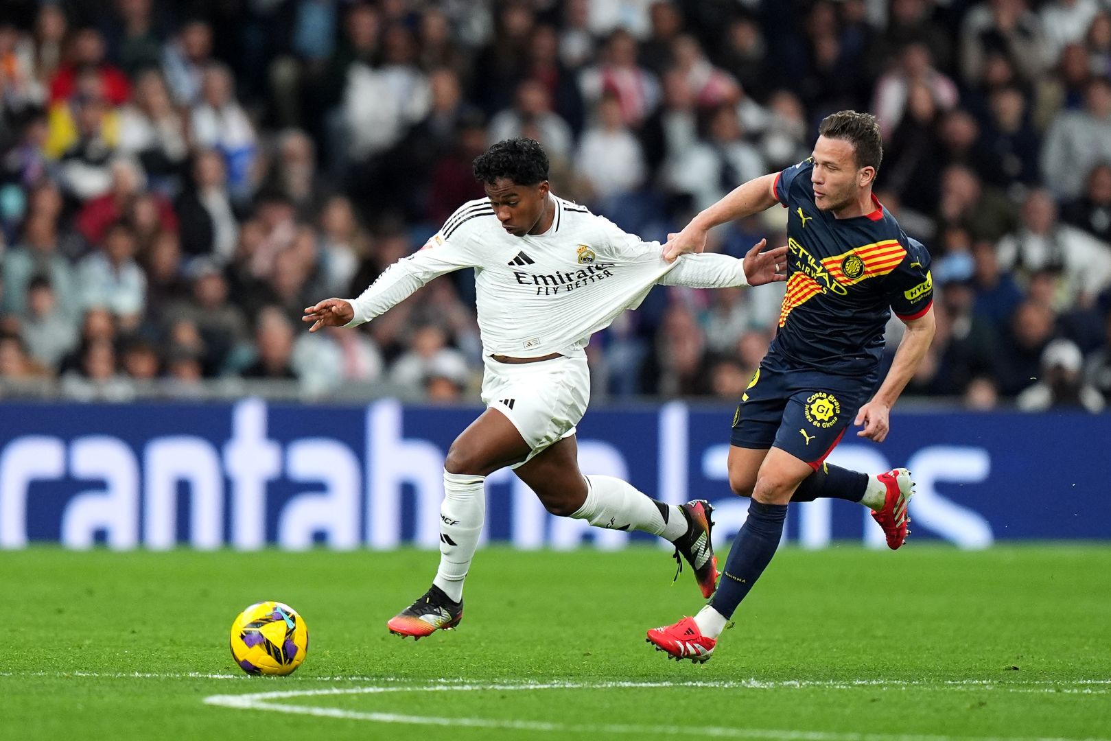 MADRID, SPAIN - FEBRUARY 23: Endrick of Real Madrid runs with the ball whilst under pressure from Arthur Melo of Girona FC during the LaLiga match between Real Madrid CF and Girona FC at Estadio Santiago Bernabeu on February 23, 2025 in Madrid, Spain.