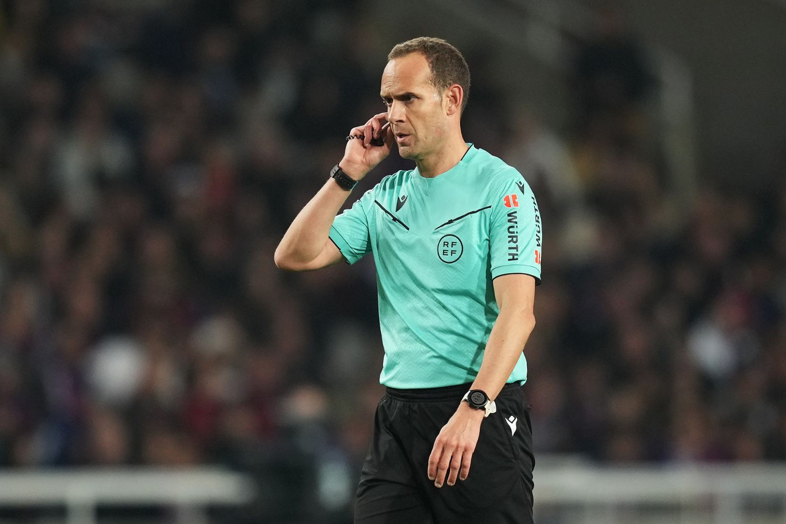BARCELONA, SPAIN - FEBRUARY 17: Referee Mario Melero Lopez listens to his ear piece during the LaLiga match between FC Barcelona and Rayo Vallecano at Estadi Olimpic Lluis Companys on February 17, 2025 in Barcelona, Spain.