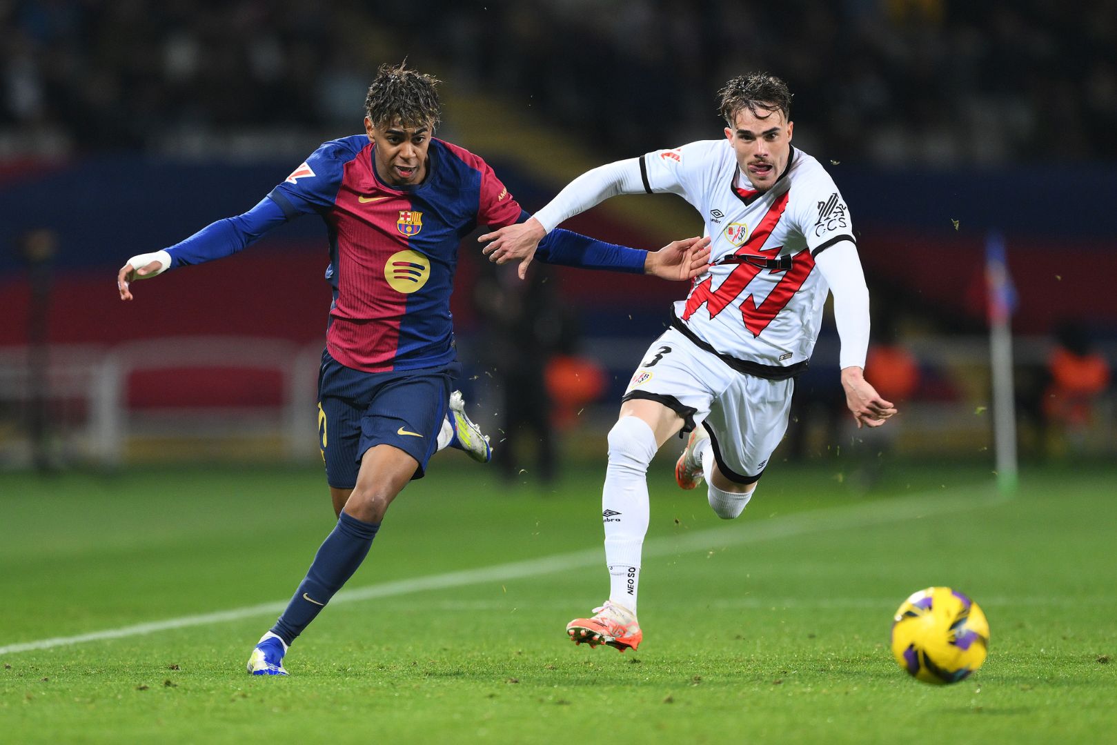 BARCELONA, SPAIN - FEBRUARY 17: Lamine Yamal of FC Barcelona and Pep Chavarria of Rayo Vallecano chase a loose ball during the LaLiga match between FC Barcelona and Rayo Vallecano at Estadi Olimpic Lluis Companys on February 17, 2025 in Barcelona, Spain.