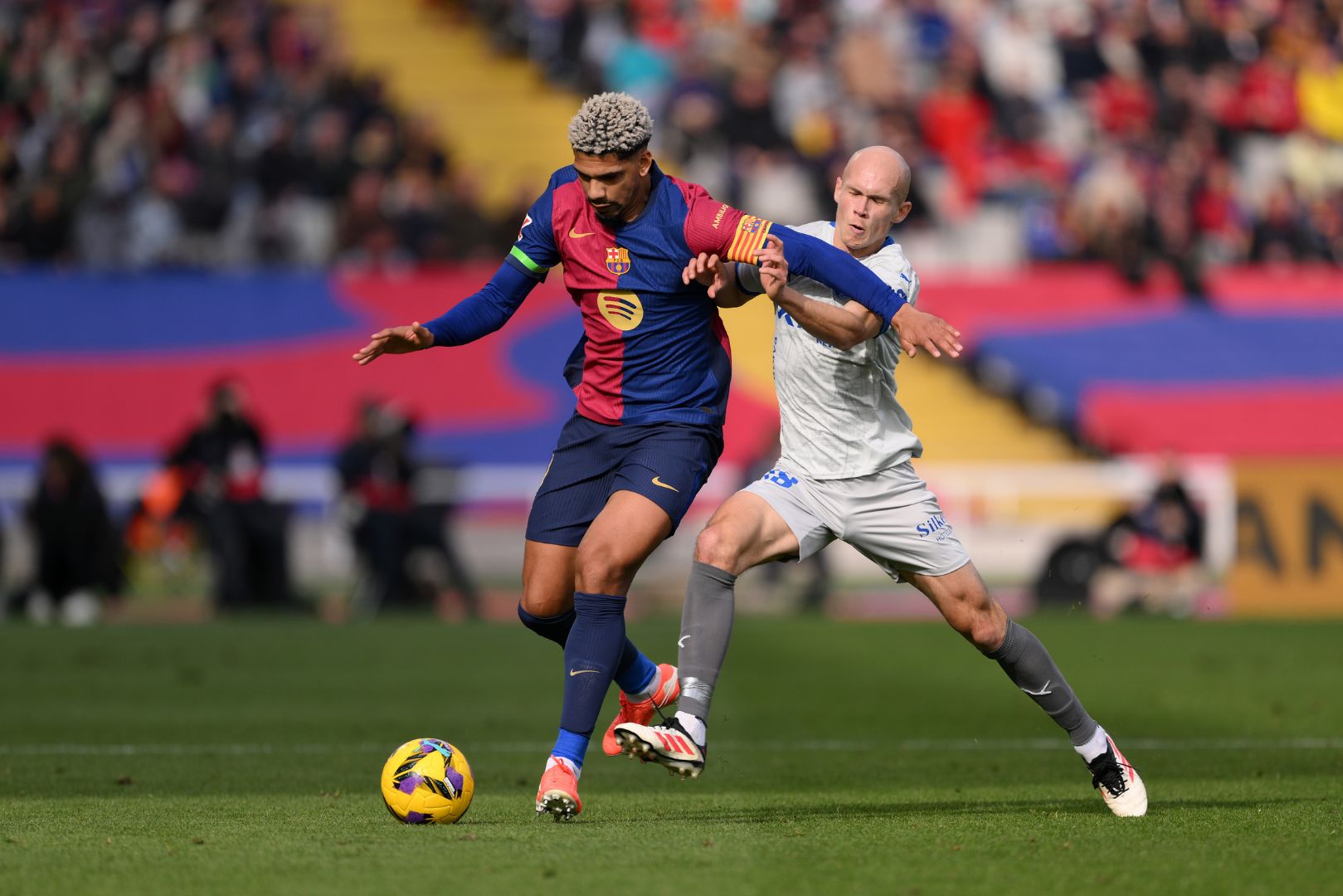 BARCELONA, SPAIN - FEBRUARY 02: Ronald Araujo of FC Barcelona is challenged by Jon Guridi of Alaves during the LaLiga match between FC Barcelona and Deportivo Alaves at Estadi Olimpic Lluis Companys on February 02, 2025 in Barcelona, Spain.