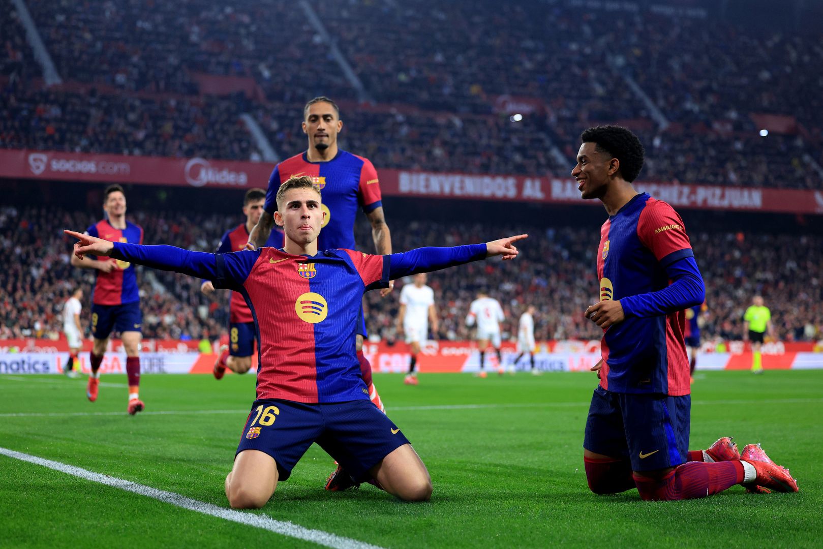 SEVILLE, SPAIN - FEBRUARY 09: Fermin Lopez of FC Barcelona celebrates scoring his team's second goal with teammate Alejandro Balde during the LaLiga match between Sevilla FC and FC Barcelona at Estadio Ramon Sanchez Pizjuan on February 09, 2025 in Seville, Spain.