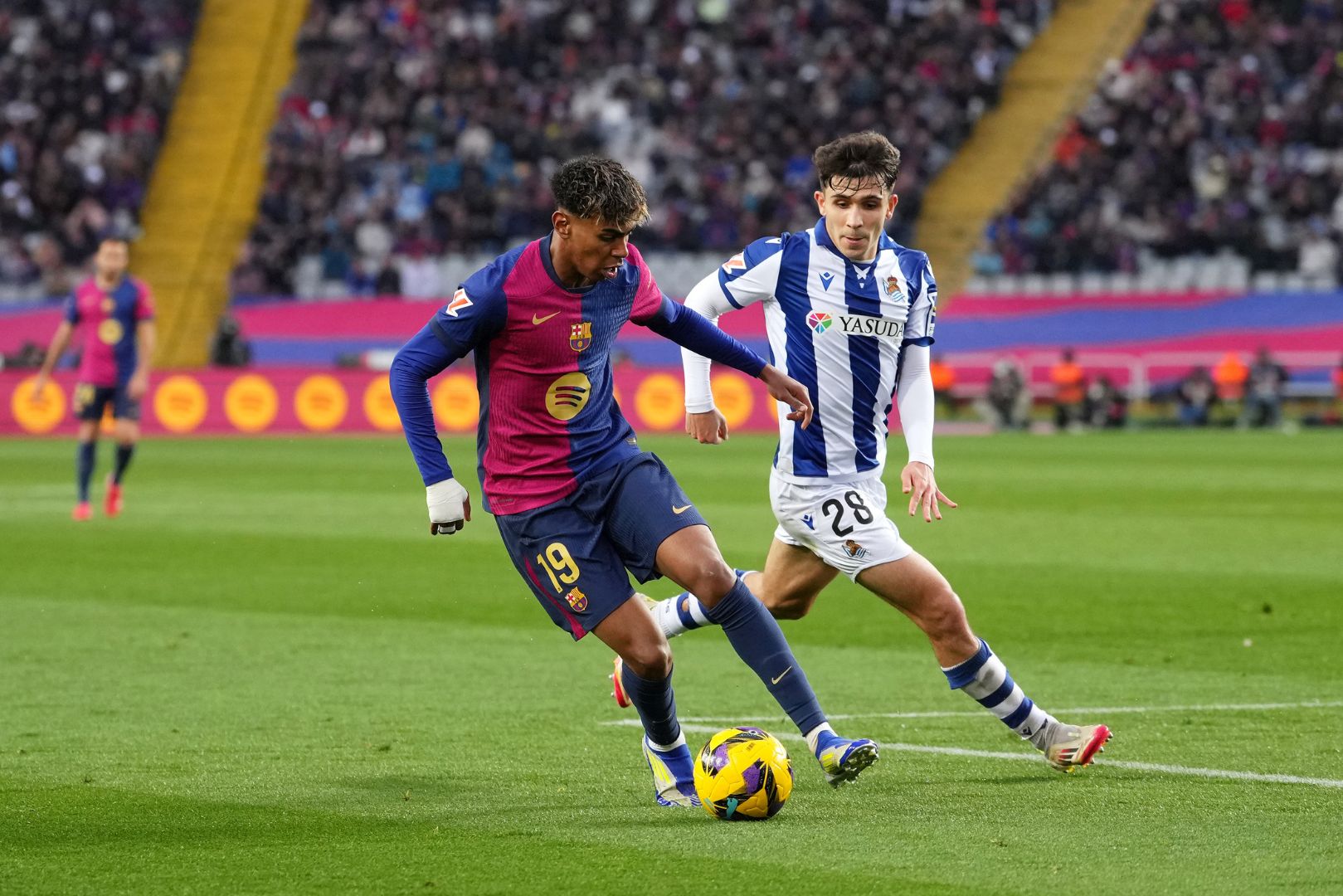 BARCELONA, SPAIN - MARCH 02: Lamine Yamal of FC Barcelona controls the ball whilst under pressure from Pablo Marin of Real Sociedad during the La Liga EA match between FC Barcelona and Real Sociedad at Estadi Olimpic Lluis Companys on March 02, 2025 in Barcelona, Spain.