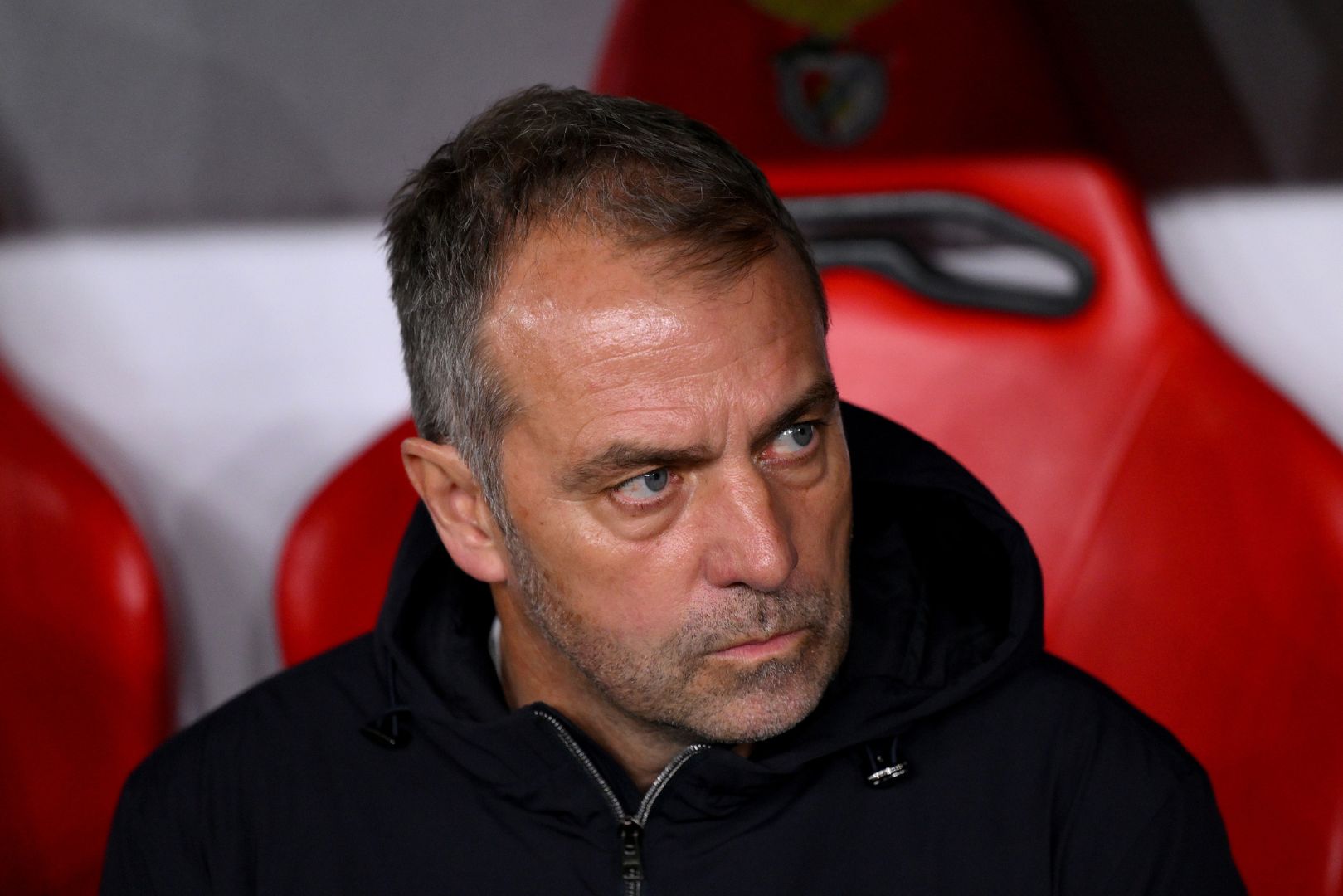 LISBON, PORTUGAL - MARCH 05: Hansi Flick, Head Coach of FC Barcelona, looks on from the dugout prior to the UEFA Champions League 2024/25 Round of 16 first Leg match between SL Benfica and FC Barcelona at Estadio da Luz on March 05, 2025 in Lisbon, Portugal.