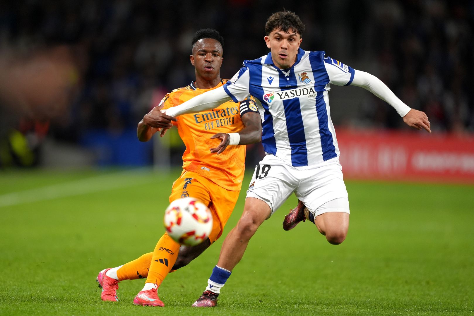 SAN SEBASTIAN, SPAIN - FEBRUARY 26: Jon Aramburu of Real Sociedad is put under pressure by Vinicius Junior of Real Madrid during the Copa del Rey Semi Final match between Real Sociedad and Real Madrid at Reale Arena on February 26, 2025 in San Sebastian, Spain.
