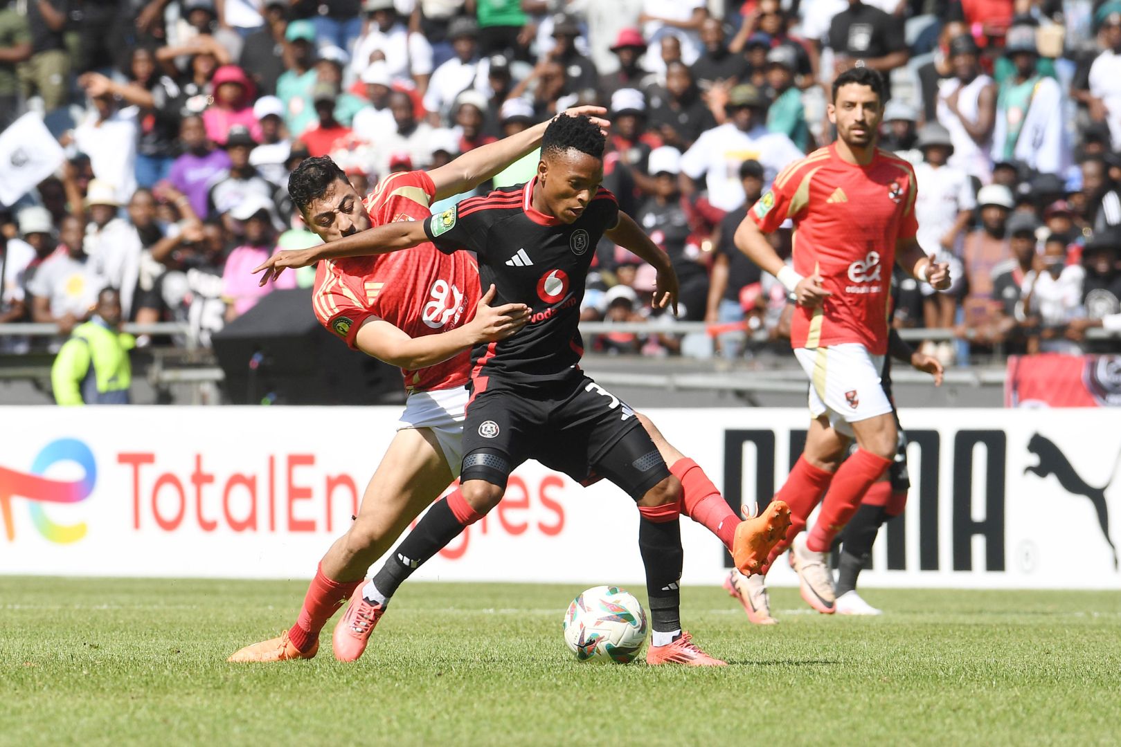 JOHANNESBURG, SOUTH AFRICA - DECEMBER 07: Relebohile Mofokeng of Orlando Pirates and Akram Elhagrasi of AL Ahly FC during the CAF Champions League match between Orlando Pirates and Al Ahly SC at Orlando Stadium on December 07, 2024 in Johannesburg, South Africa.
