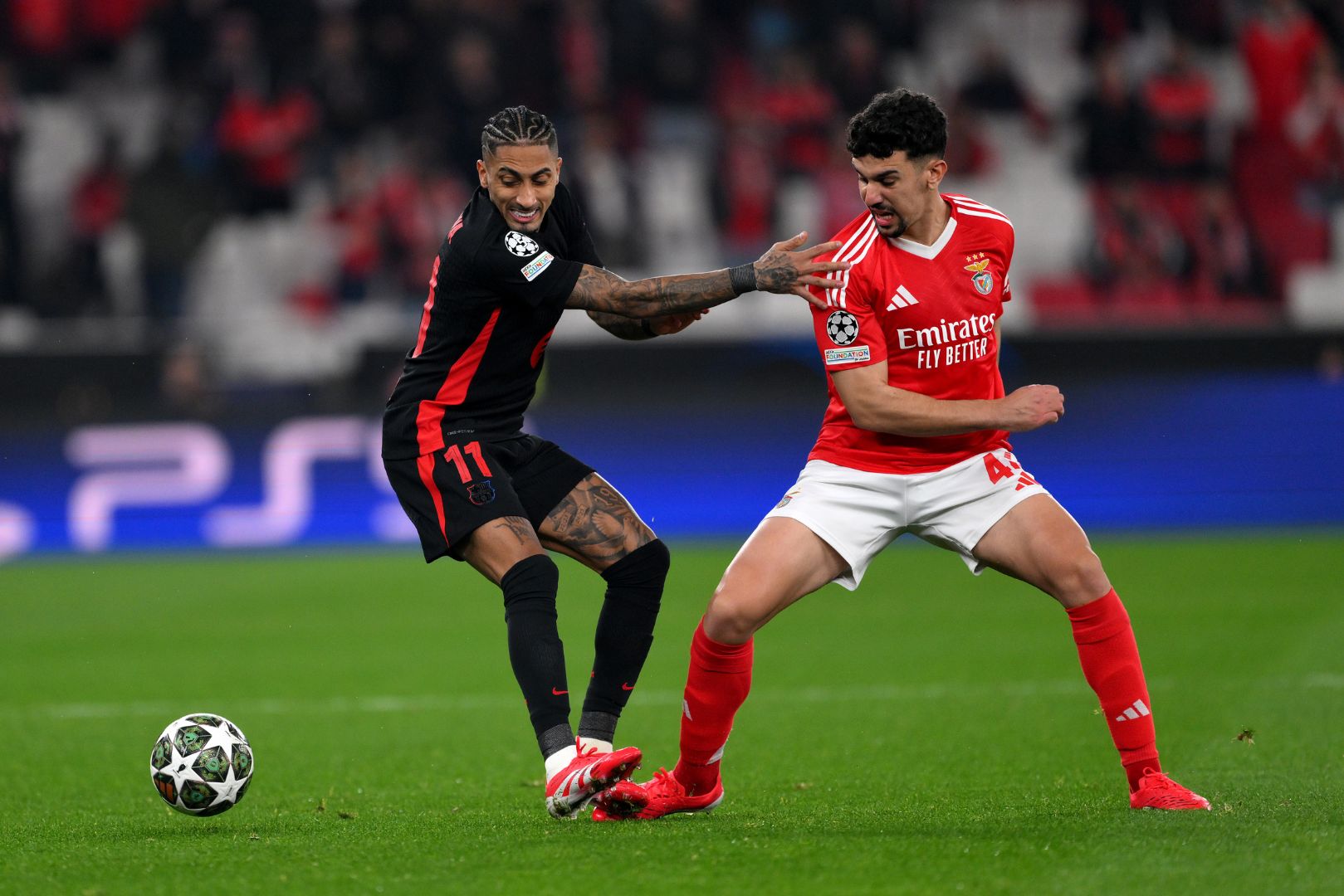 LISBON, PORTUGAL - MARCH 05: Raphinha of FC Barcelona battles for possession with Tomas Araujo of SL Benfica during the UEFA Champions League 2024/25 Round of 16 first Leg match between SL Benfica and FC Barcelona at Estadio da Luz on March 05, 2025 in Lisbon, Portugal.